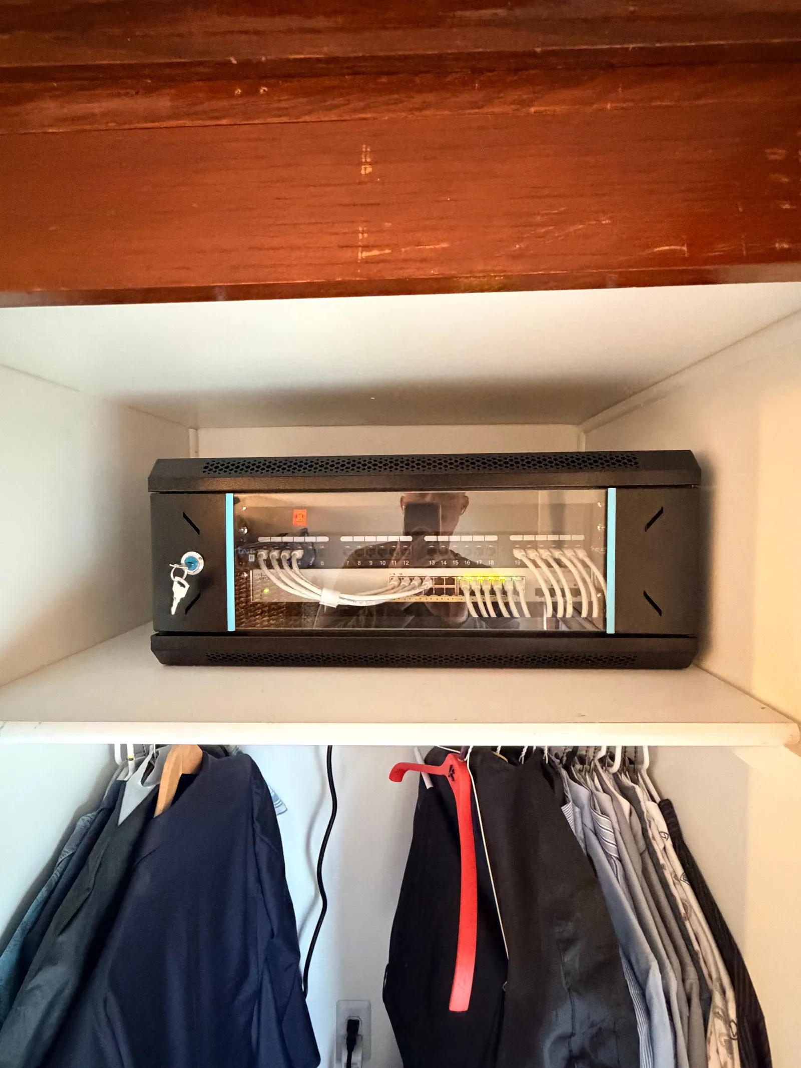 Locked network cabinet with tidy cabling installed inside a hall closet