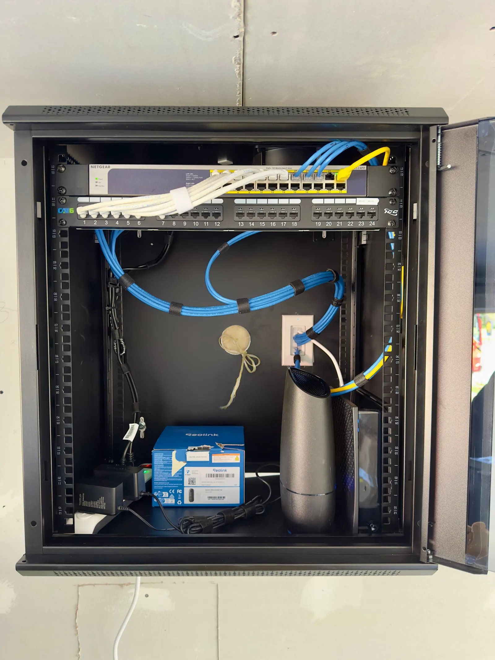 Professionally organized home network rack with labeled Cat6 cabling after a clean installation