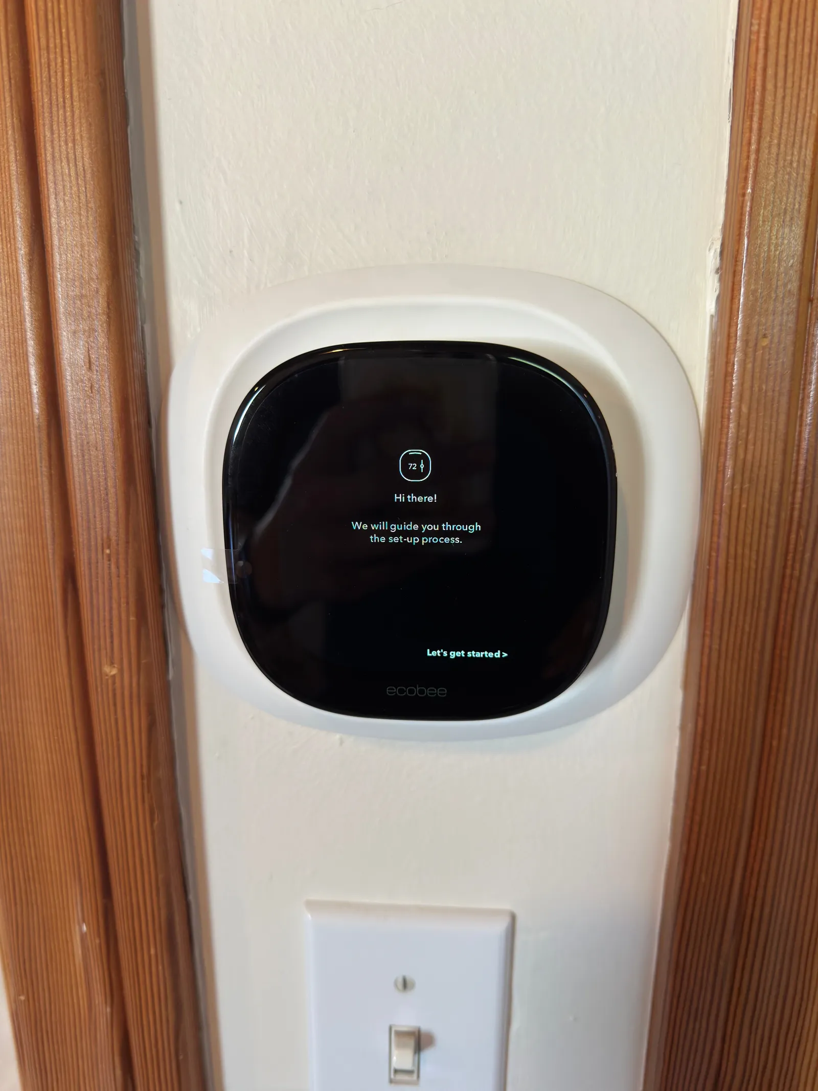 Smart thermostat on a home wall showing its setup screen right after installation
