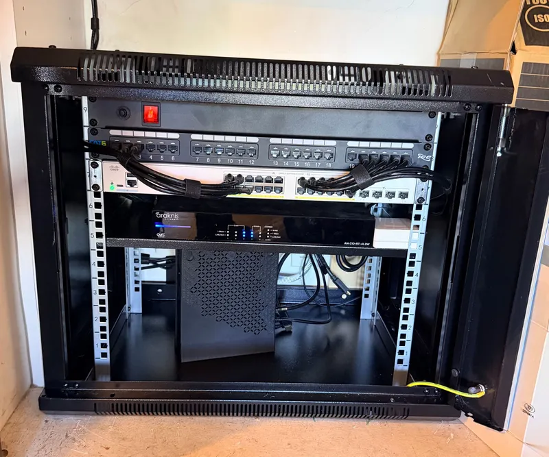 Compact network rack with patch panel and router installed during a structured wiring job